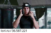Young man boxer puts on a protective boxing helmet. Стоковое видео, видеограф Константин Шишкин / Фотобанк Лори
