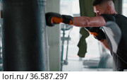 Young man boxer training with a punching bag. Стоковое видео, видеограф Константин Шишкин / Фотобанк Лори