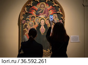 Женщины фотографируют икону «Троицын день (Пятидесятница)» работы Таддео ди Бартоло. Выставка «Искусство Средневековья. Шедевры из собрания Национальной Галереи Умбрии». Эрмитаж. Санкт-Петербург (2021 год). Редакционное фото, фотограф Румянцева Наталия / Фотобанк Лори
