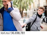 Teenager thieving wallet from man pocket. Стоковое фото, фотограф Яков Филимонов / Фотобанк Лори