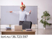 Funny young male teacher magician in the classroom. Стоковое фото, фотограф Elnur / Фотобанк Лори