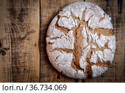 Натюрморт, домашний ржаной хлеб, посыпанный мукой, на столе, сделанном из старых деревянных досок. вид сверху, крупным планом. Стоковое фото, фотограф Алексей Крылов / Фотобанк Лори