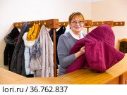 Smiling elderly woman checkroom attendant working in theater. Стоковое фото, фотограф Яков Филимонов / Фотобанк Лори