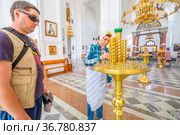 an elderly woman to put a candle in a candlestick in a church for a commemoration (2021 год). Редакционное фото, фотограф Акиньшин Владимир / Фотобанк Лори
