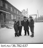 Несколько мужчин стоят рядом, они позируют стоя рядом с деревянным домом, зимний портрет мужчин с ребенком, несколько человек в теплой зимней одежде , Токарев и Морозов в гостях у Тетериных. Редакционное фото, фотограф Варфоломей Тетерин / Фотобанк Лори