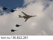 Группа истребителей СУ-35С и сверхзвуковой стратегический бомбардировщик дальней авиации Ту-160 во время генеральной репетиции парада пролетают над Красной площадью Москвы (2021 год). Редакционное фото, фотограф Free Wind / Фотобанк Лори