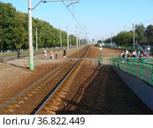 Люди переходят железнодорожные пути по настилу рядом с железнодорожной платформой станции Удельная. Раменский район. Московская область (2011 год). Редакционное фото, фотограф lana1501 / Фотобанк Лори
