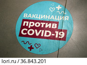 "Вакцинация против COVID-19", голубая наклейка - указатель на полу. ТРЦ Columbus, Центр госуслуг "Мои Документы". Пандемия коронавируса COVID-19 в Москве (2021 год). Стоковое фото, фотограф Щеголева Ольга / Фотобанк Лори