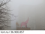 Москва, микрорайон Марфино, СВАО. В плотном тумане фигура розового слона на фоне фасадов домов едва видна (2021 год). Редакционное фото, фотограф Наталья Николаева / Фотобанк Лори