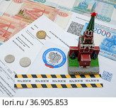 Фигурка Спасской башни московского Кремля, Конверт с эмблемой налоговой инспекции, российские деньги и оградительная лента с надписью "налоги" (2021 год). Редакционное фото, фотограф Цибаев Алексей / Фотобанк Лори