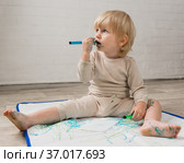 Девочка с водорастворимыми детскими фломастерами сидит на скатерти для рисования. Стоковое фото, фотограф Наталья Гармашева / Фотобанк Лори