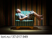 Пожилой мужчина с бутылкой пива в темной комнате при свете лампы. Стоковое фото, фотограф Александр Романов / Фотобанк Лори