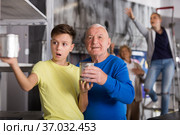 Grandson together with his grandfather solve the riddles of quest room. Стоковое фото, фотограф Яков Филимонов / Фотобанк Лори