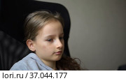 Little sad girl is sitting on black office chair, punishment, serious face. Стоковое видео, видеограф Ольга Балынская / Фотобанк Лори