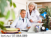 Two physicians working with case histories on laptop in office. Стоковое фото, фотограф Яков Филимонов / Фотобанк Лори