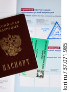 Сертификат о вакцинации против новой коронавирусной инфекции (COVID-19) вакциной "Спутник Лайт", российский паспорт и карточка медицинского страхования (2021 год). Редакционное фото, фотограф Щеголева Ольга / Фотобанк Лори
