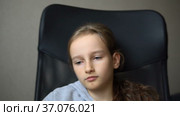 Little sad girl is sitting on black office chair, punishment, serious face. Стоковое видео, видеограф Ольга Балынская / Фотобанк Лори