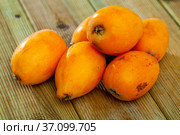 Closeup of whole ripe yellow loquat on wooden table. Vitamin fruits. Стоковое фото, фотограф Яков Филимонов / Фотобанк Лори