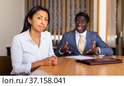Saddened businesswoman sitting in office with dissatisfied male colleague. Стоковое фото, фотограф Яков Филимонов / Фотобанк Лори