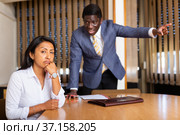 Saddened businesswoman sitting in office with dissatisfied male colleague. Стоковое фото, фотограф Яков Филимонов / Фотобанк Лори