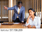Saddened businesswoman sitting in office with dissatisfied male colleague. Стоковое фото, фотограф Яков Филимонов / Фотобанк Лори