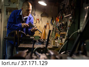 Gunsmith assembling smallbore sporting pistol in workshop. Стоковое фото, фотограф Яков Филимонов / Фотобанк Лори