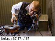 Man watching in monocle to check hitting target in shooting range. Стоковое фото, фотограф Яков Филимонов / Фотобанк Лори