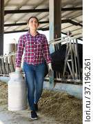 Female farmer carrying milk churn at dairy farm. Стоковое фото, фотограф Яков Филимонов / Фотобанк Лори