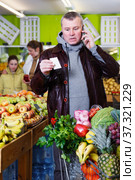Man specifying shopping list in store. Стоковое фото, фотограф Яков Филимонов / Фотобанк Лори