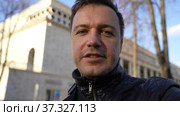 Businessman standing outdoors with office building in background, looking at camera and talking. Стоковое видео, видеограф Данила Большаков / Фотобанк Лори
