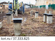 Concrete pile drilling with mechanical piledriver, foundation for wooden frame house. Стоковое фото, фотограф Кекяляйнен Андрей / Фотобанк Лори