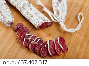 Slicing delicious Spanish smoked sausage fuete. Стоковое фото, фотограф Яков Филимонов / Фотобанк Лори