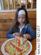 Girl eating pizza in a cafe. Стоковое фото, фотограф Марина Володько / Фотобанк Лори