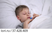 The sick boy lies in bed. High body temperature. The child has a cold. Coronavirus infection omicron. Flu. Treatment at home. Hospital for childcare. Child has a headache. Home quarantine. Стоковое видео, видеограф Ирина Ткачук / Фотобанк Лори