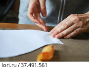 Женщина прикалывает выкройку к ткани. Working process of a dressmaker. Tailor attaches sewing pattern to a fabric with a straight pin. Стоковое фото, фотограф Ekaterina M / Фотобанк Лори