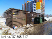 Новая закрытая помойка с мусорными баками открыта нараспашку и мусор вокруг нее в городе весной (2022 год). Стоковое фото, фотограф Sergei Gorin / Фотобанк Лори