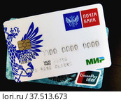 Карты "Мир" и UnionPay лежат на черном фоне (2022 год). Редакционное фото, фотограф Ludmila Zyubina / Фотобанк Лори