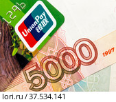 Карта UnionPay на фоне пятитысячной купюры (2022 год). Редакционное фото, фотограф SevenOne / Фотобанк Лори