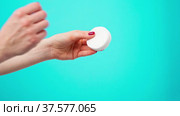 Female hand holding cosmetic cotton discs against blue background. Стоковое видео, видеограф Сергей Толмачёв / Фотобанк Лори
