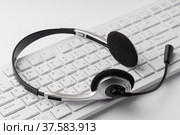 Headset on a laptop keyboard on office table. Стоковое фото, фотограф Сергей Толмачёв / Фотобанк Лори
