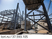 Phosphate fertilizers plant. New industrial building construction. Assembling steel structure. Concrete and metal elements on blue sky with light clouds. Стоковое фото, фотограф Alexey Rezvykh / Фотобанк Лори