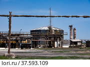 Old rusted oil storage tanks and pipe on soviet factory. Blue sky background. Стоковое фото, фотограф Alexey Rezvykh / Фотобанк Лори