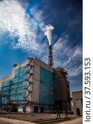Smoking factory chimney with white smoke. Blue industrial building of phosphoric fertilizers plant. On the blue sky with light clouds. Стоковое фото, фотограф Alexey Rezvykh / Фотобанк Лори