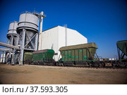 Aktobe region/Kazakhstan - May 04 2019: Phosphate fertilizers plant loading station. Loading hopper. Hopper car train terminal. Green railway carriages. Стоковое фото, фотограф Alexey Rezvykh / Фотобанк Лори