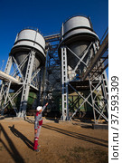Phosphate fertilizers plant. Railway hopper car terminal. Fertilizers loader and train. Worker in white helmet controlling process. Стоковое фото, фотограф Alexey Rezvykh / Фотобанк Лори