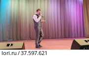 На сцене молодой человек исполняет песню. On stage, a young man performs a song. Стоковое видео, видеограф Мария / Фотобанк Лори