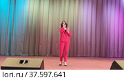 На сцене девушка исполняет песню. On stage, a girl performs a song. Редакционное видео, видеограф Мария / Фотобанк Лори