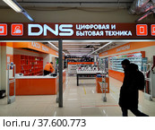 Силуэт человека на фоне магазина цифровой и бытовой техники DNS (2022 год). Редакционное фото, фотограф Ирина Терентьева / Фотобанк Лори