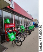 Велопарковка с велосипедами курьеров возле кафе KFC в Москве (2022 год). Редакционное фото, фотограф Ирина Терентьева / Фотобанк Лори