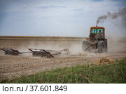 Spring sowing season. Tractor cultivated field soil with harrow. Стоковое фото, фотограф Alexey Rezvykh / Фотобанк Лори
